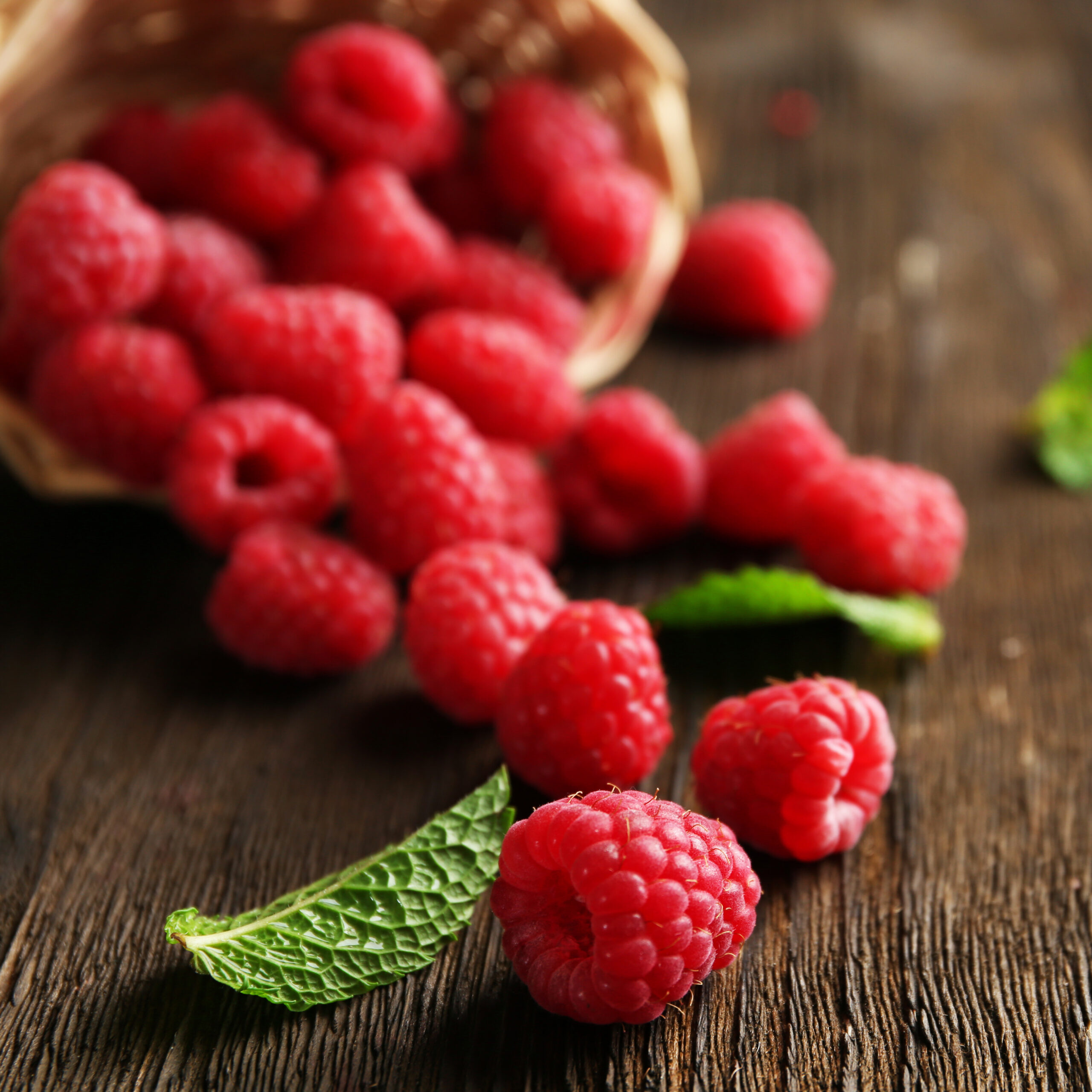 Fresh red raspberries on wooden table, closeup