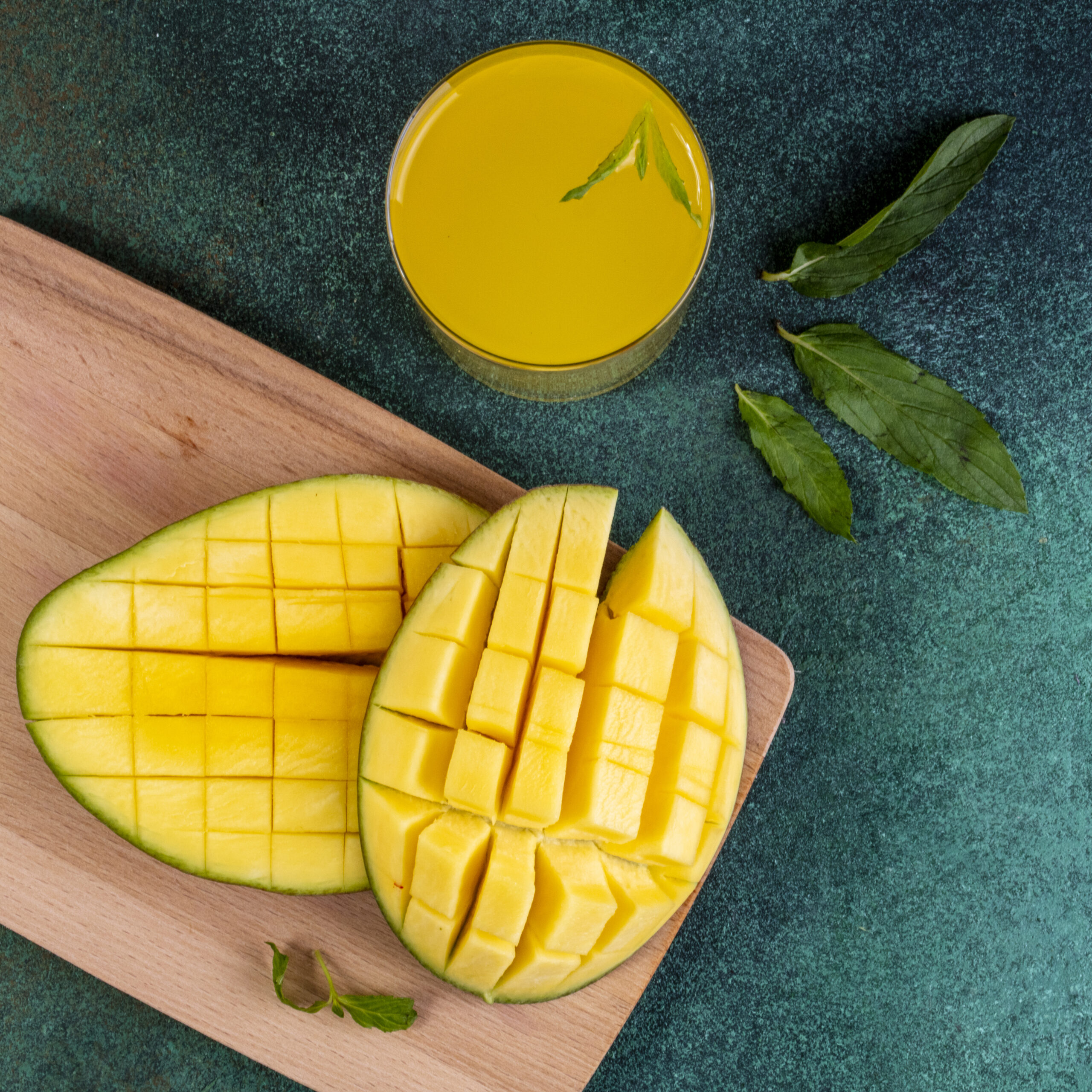 top view copy space sliced mango on a blackboard with a glass o